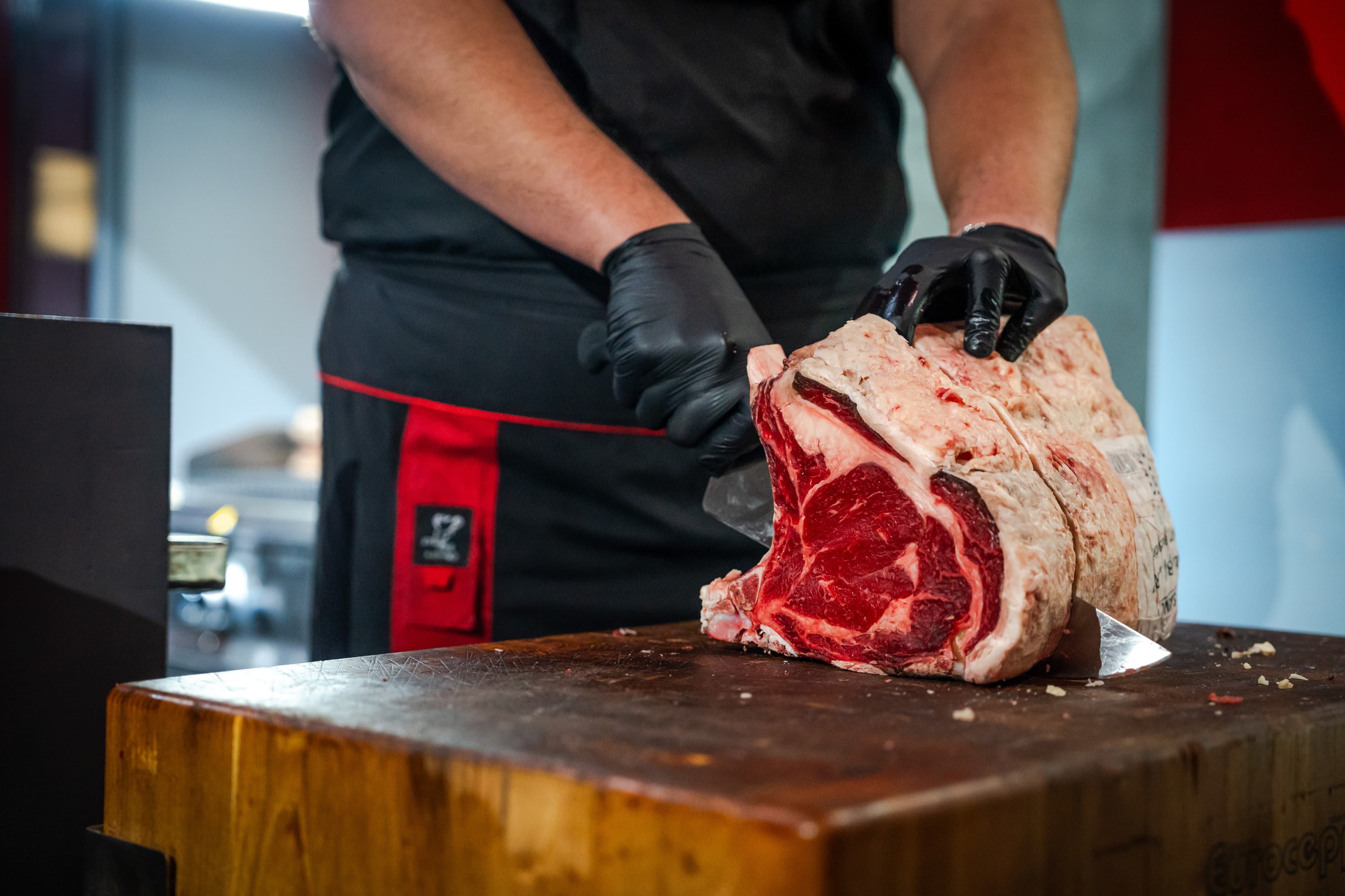 Chef che lavora un taglio di carne su ceppo da macelleria