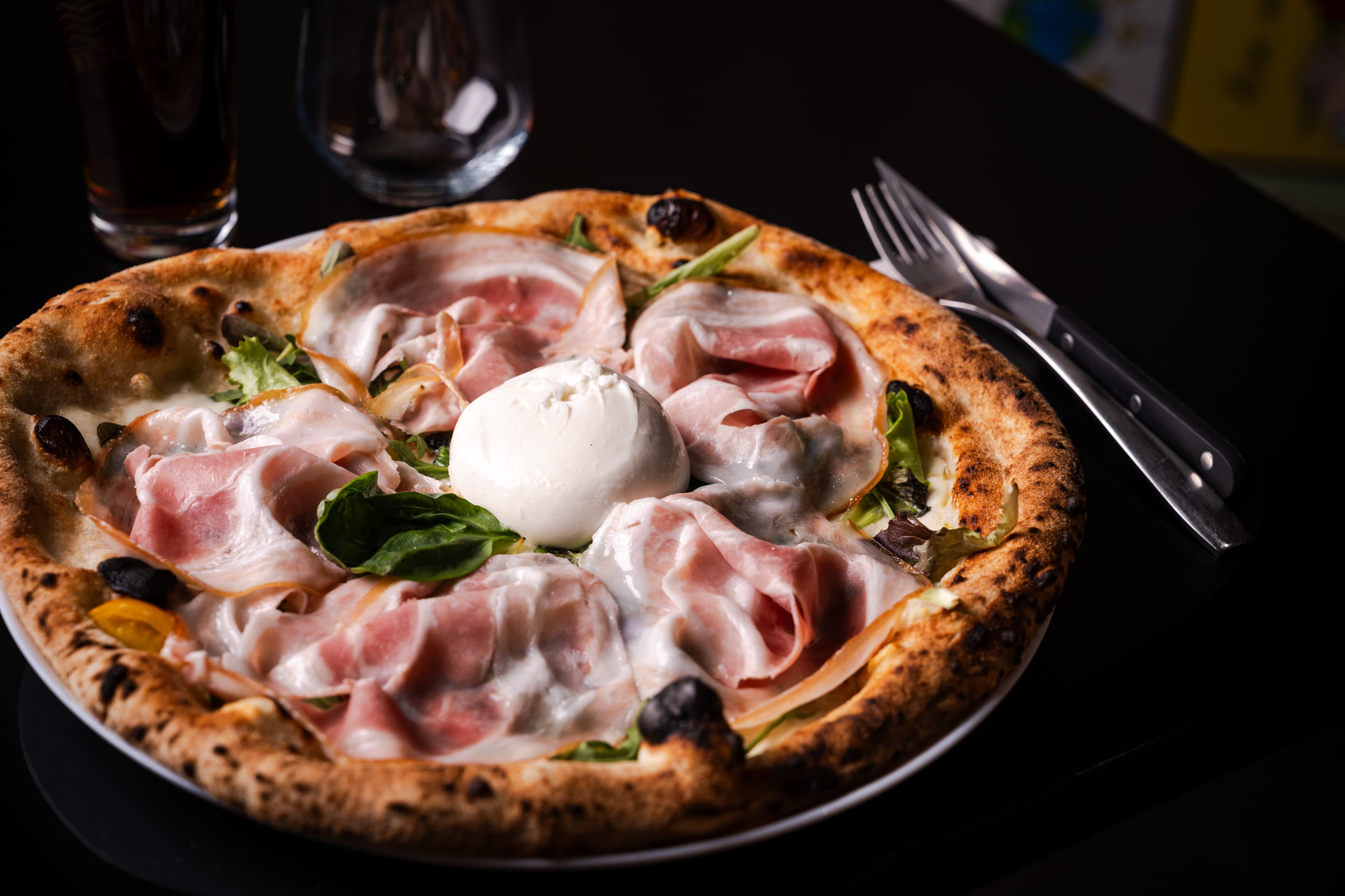 Pizza gourmet con burrata, salumi e basilico